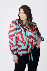 Mayes NYC Rosen Tie Neck Ruched Shoulder Blouse in Blue and Red Circle Stripes worn by model Megan Smith