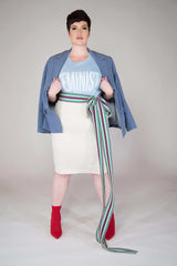 short haired model wearing an ecrue colored pull on hight waisted, form fitting skirt. Finished with 2 inch elastic waist and center back kick pleat Material is a Viscose/Poly/Spandex  garment is MADE IN NEW YORK CITY BY Mayes NYC
